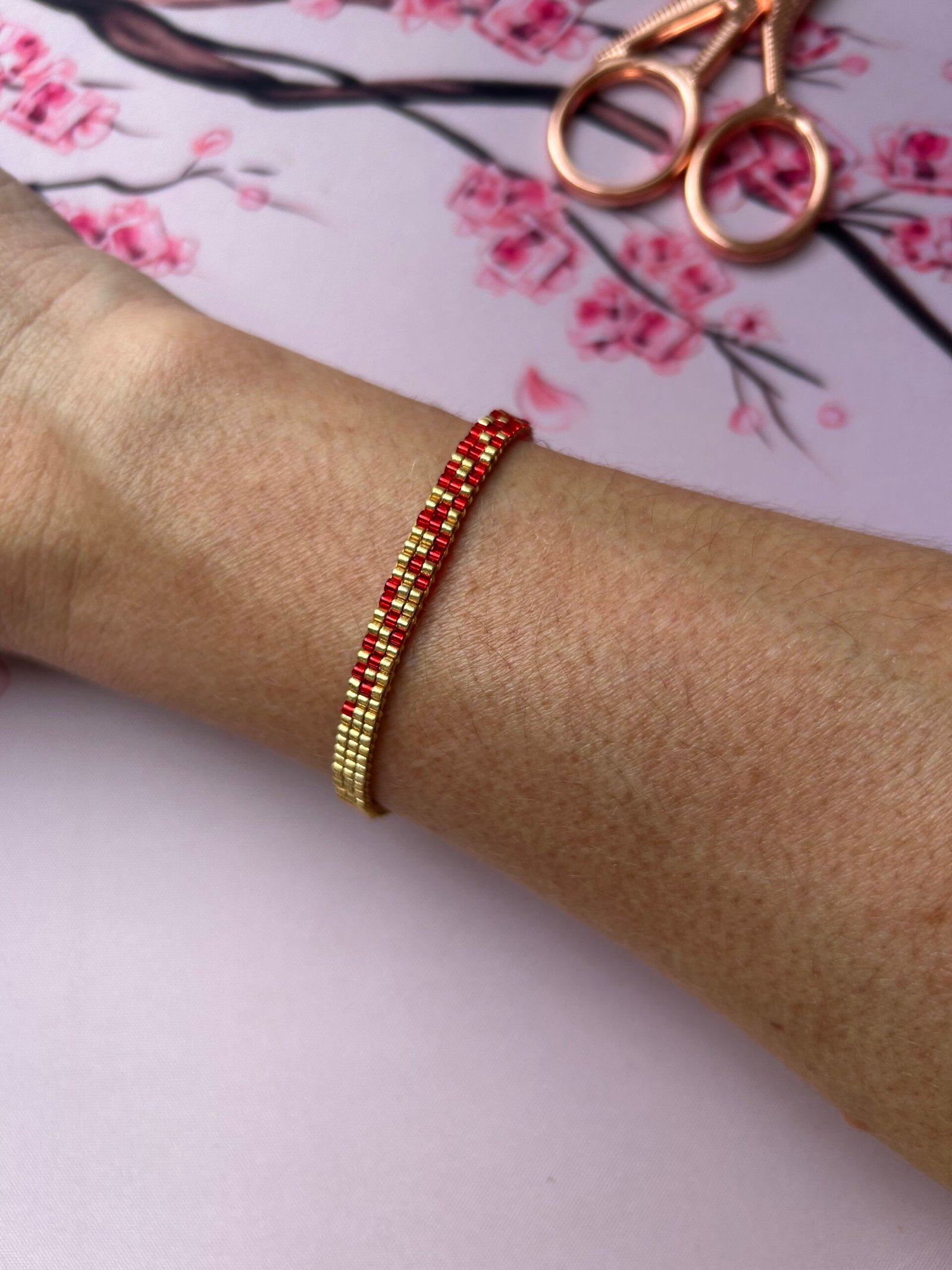 Flamme est un bracelet fin aux nuances de rouge intense et d’or lumineux, symbole de passion, d’énergie et de force intérieure. Une création vibrante, qui réchauffe le cœur et illumine le poignet.