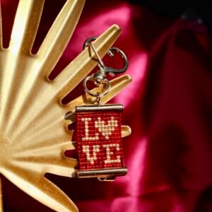 Porte-clés romantique en perles Miyuki, fond rouge et inscription LOVE dorée, avec fermoir cœur finition or. Un petit bijou à emporter partout.