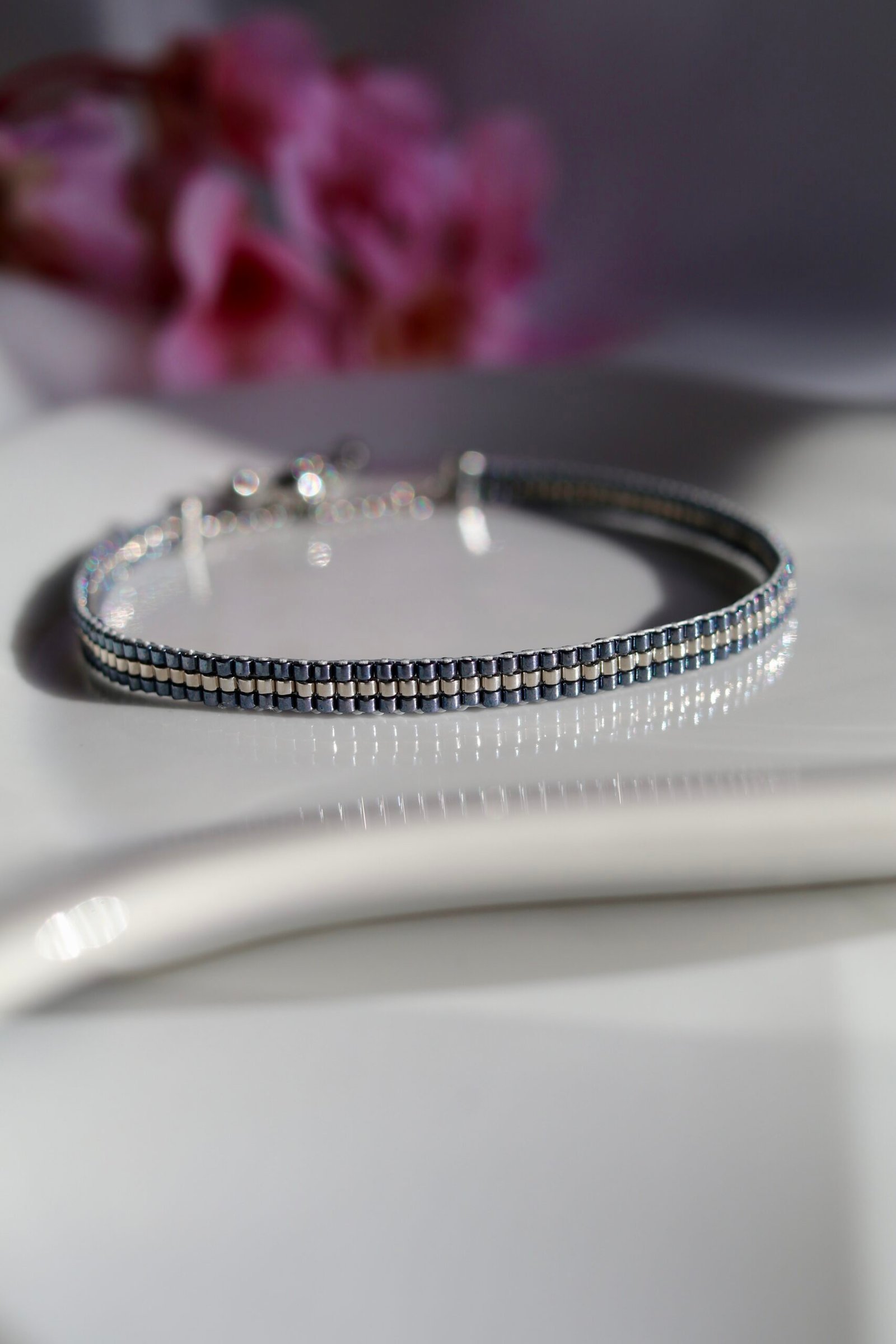 Un bracelet au caractère minéral et lumineux, mêlant un gris argenté palladium à un contour gunmetal bleu acier. Une création sobre, moderne et élégante, pensée comme un bijou intemporel pour homme.