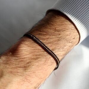 Un bracelet au contraste intense, où le noir profond révèle une ligne centrale couleur bronze, comme une lumière chaude qui bat au cœur de la nuit. Un bijou masculin, élégant et chargé de sens, symbole de force, de loyauté et d’émotions discrètes.