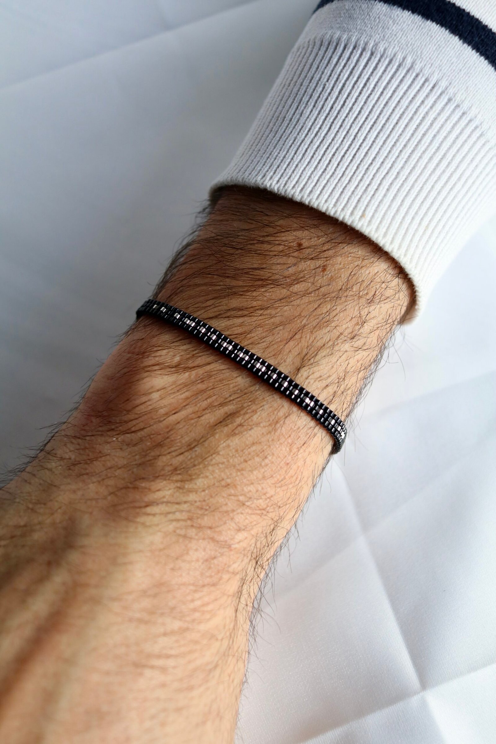 Tissé à la main en perles Miyuki noires et argent, le bracelet Secret Love dissimule en code morse le message « I love U ». Un bijou sobre et élégant, porteur d’un message intime que seuls les initiés savent lire.