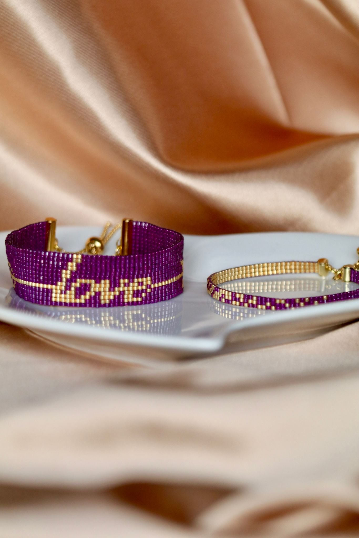 Cupidon est un bracelet large et affirmé, où le mot Love brodé en perles dorées est traversé par une flèche, symbole d’amour éternel et de passion. Un bijou fort, lumineux et profondément romantique.