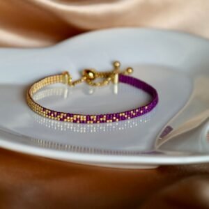 Divina est un bracelet fin aux nuances de violet profond et d’or lumineux, symbole de sagesse, d’intuition et de lumière intérieure. Une création délicate et intemporelle, à porter comme un talisman précieux au quotidien.