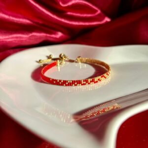 Flamme est un bracelet fin aux nuances de rouge intense et d’or lumineux, symbole de passion, d’énergie et de force intérieure. Une création vibrante, qui réchauffe le cœur et illumine le poignet.