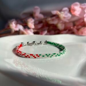 Bracelet fin tissé à la main en perles Miyuki. Une alliance de vert, argent et rouge pour symboliser l’ancrage, la force intérieure et la fierté de ses racines. Élégant, intemporel, profondément personnel.