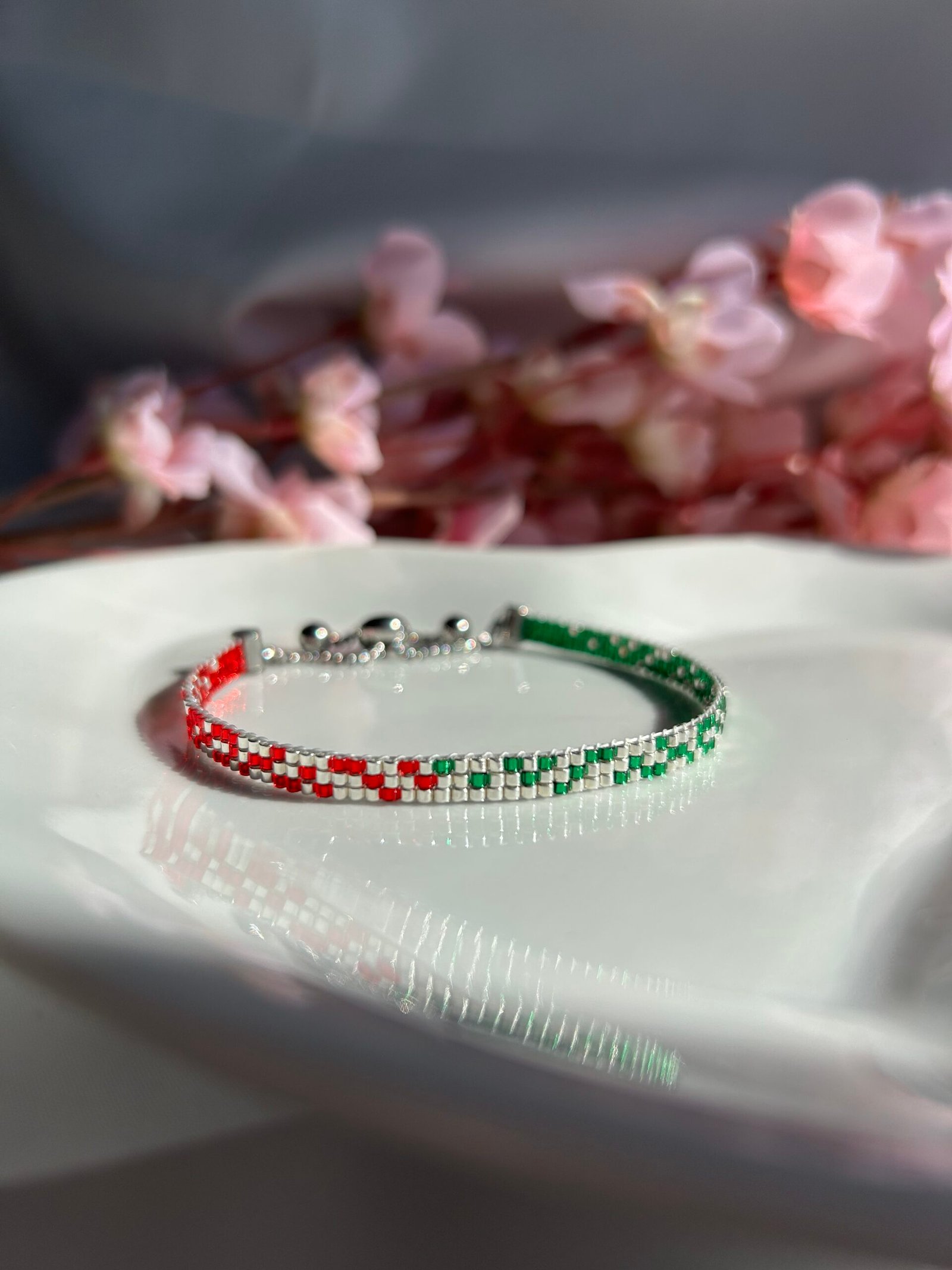 Bracelet fin tissé à la main en perles Miyuki. Une alliance de vert, argent et rouge pour symboliser l’ancrage, la force intérieure et la fierté de ses racines. Élégant, intemporel, profondément personnel.