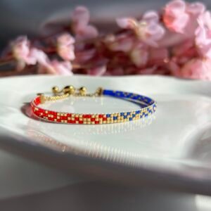 Bracelet fin tissé à la main en perles Miyuki. Une alliance de bleu, or et rouge pour symboliser la profondeur, la lumière et l’assurance. Sophistiqué, intemporel, profondément personnel.