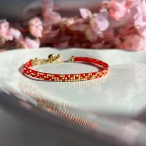Bracelet fin tissé à la main en perles Miyuki. Une alliance de rouge et d’or pour symboliser la passion, la lumière et la force intérieure. Vibrant, intemporel, profondément personnel.