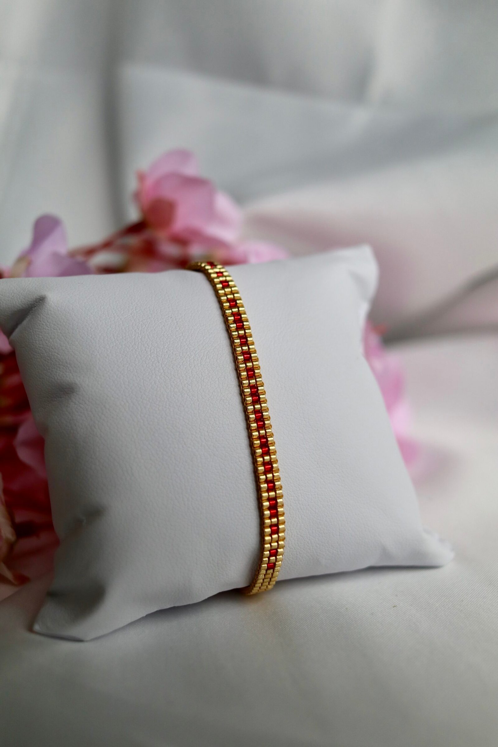Bracelet tissé à la main en perles Miyuki dorées et rouges, le Secret Love – Ruby Gold révèle en code morse le message « I Love U ». Une création lumineuse et passionnée, symbole d’un amour discret mais intense.