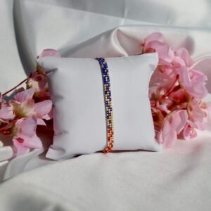 Bracelet fin tissé à la main en perles Miyuki. Une alliance de bleu, or et rouge pour symboliser la profondeur, la lumière et l’assurance. Sophistiqué, intemporel, profondément personnel.