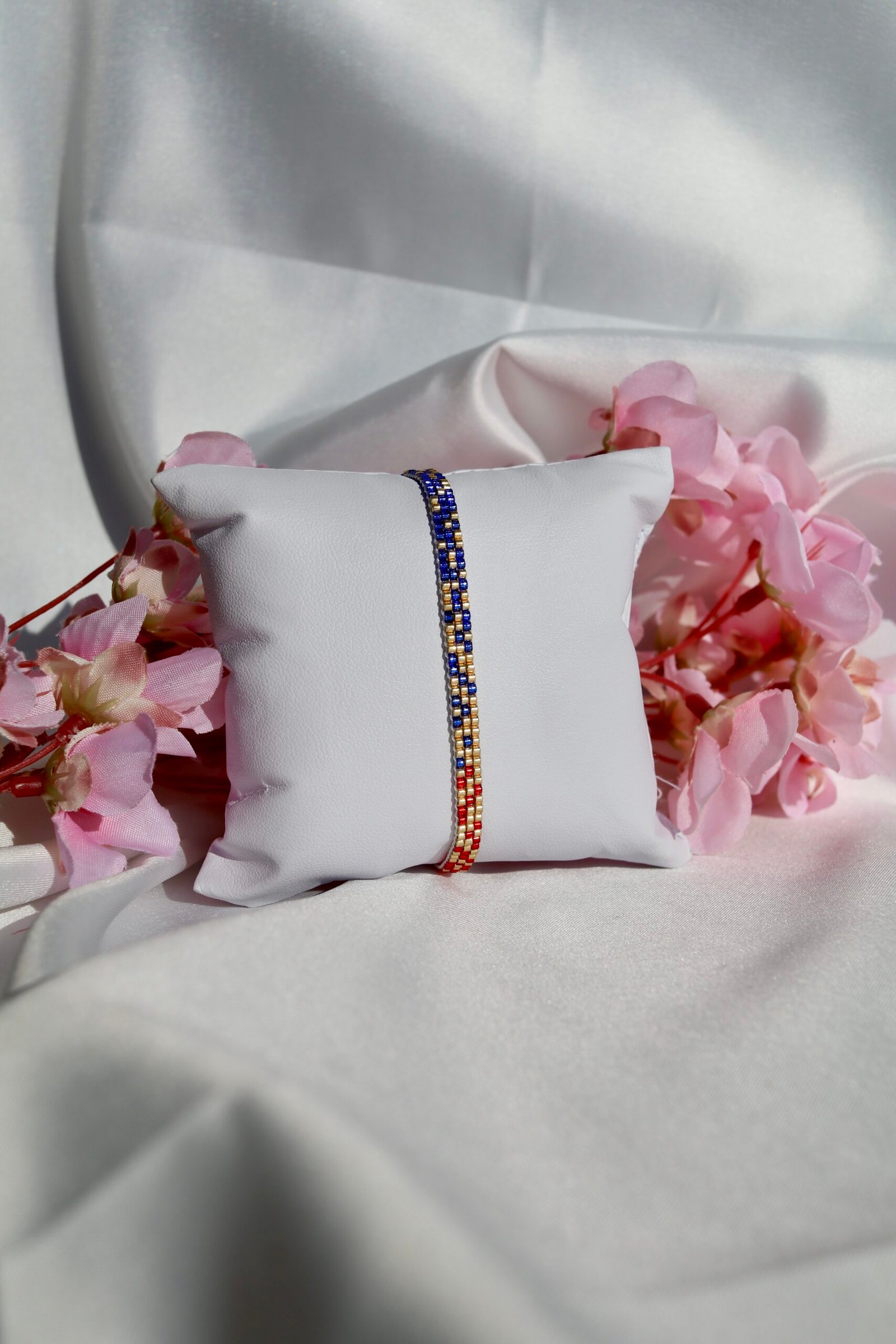 Bracelet fin tissé à la main en perles Miyuki. Une alliance de bleu, or et rouge pour symboliser la profondeur, la lumière et l’assurance. Sophistiqué, intemporel, profondément personnel.