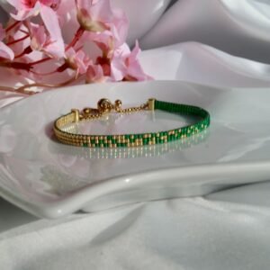 Émeraude d’Or est un bracelet fin tissé à la main en perles Miyuki, mêlant vert profond et or lumineux. Un bijou élégant et intemporel, inspiré par la nature et la lumière.