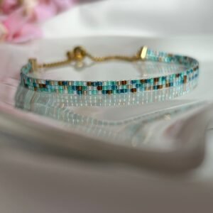 Surf and Sand est un bracelet fin tissé à la main en perles Miyuki, mêlant des nuances de bleu océan, sable chaud et or profond. Un bijou lumineux et apaisant, inspiré par la mer, le soleil et la liberté.