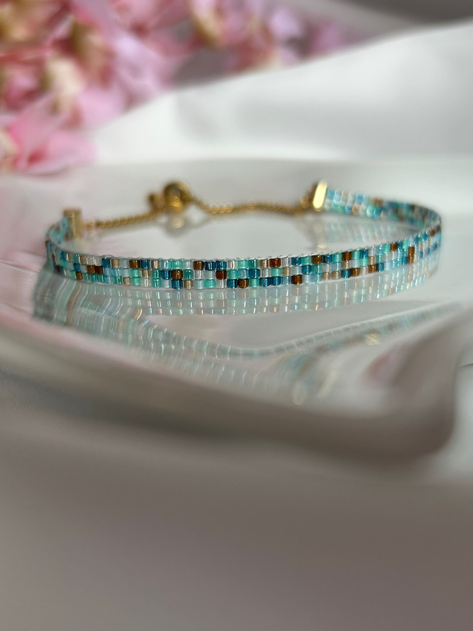 Surf and Sand est un bracelet fin tissé à la main en perles Miyuki, mêlant des nuances de bleu océan, sable chaud et or profond. Un bijou lumineux et apaisant, inspiré par la mer, le soleil et la liberté.