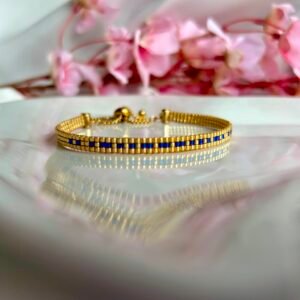 Bracelet tissé à la main en perles Miyuki dorées et bleues, le Secret Love – Sapphire Gold révèle en code morse le message « I Love U ». Une création lumineuse et passionnée, symbole d’un amour discret mais intense.