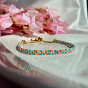 Summer Vacation est un bracelet fin tissé à la main en perles Miyuki aux nuances de turquoise, rose et orange. Une création lumineuse et pétillante qui évoque les vacances, les plages paradisiaques et les plus beaux souvenirs d'été.